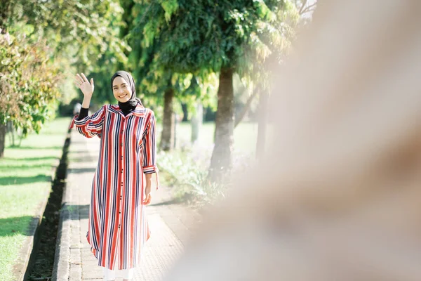 Mujeres musulmanas en hijabs al aire libre en un día soleado con un amigo feliz —  Fotos de Stock