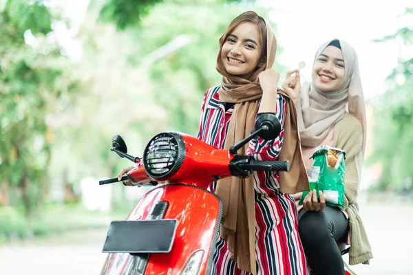 Feliz musulmana niñas a caballo scooter disfrutar de vacaciones de verano —  Fotos de Stock