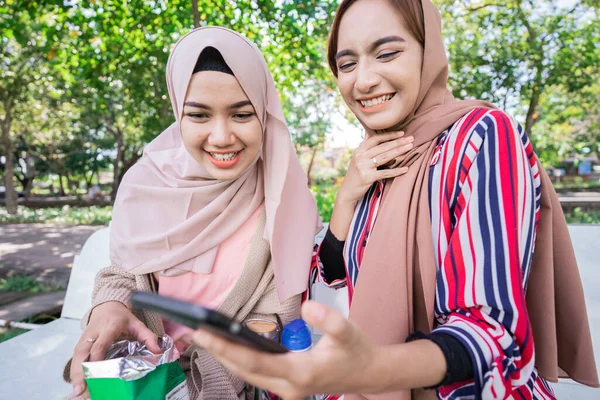 Muslimische Frau mit Kopftuch trifft Freunde und telefoniert im Park — Stockfoto