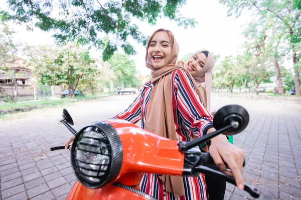 Happy muslim girls riding scooter enjoy summer vacation — Stock Photo, Image