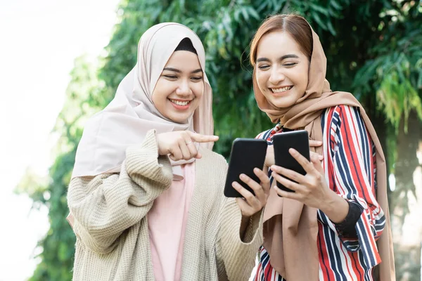 Muslimische Frau mit Kopftuch trifft Freunde und telefoniert im Park — Stockfoto