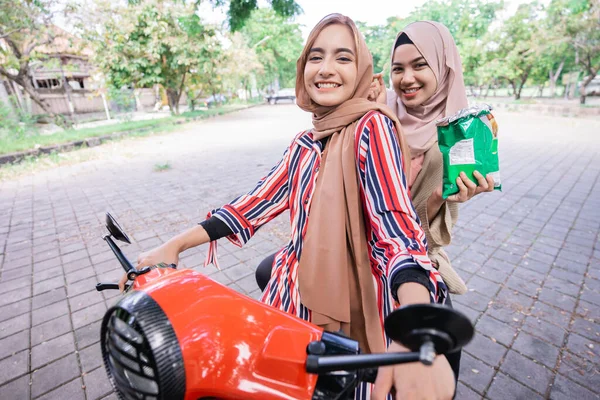 幸せなイスラム教徒の女の子は夏休みを楽しむスクーターに乗る — ストック写真