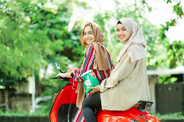 Meninas muçulmanas felizes equitação scooter desfrutar de férias de verão — Fotografia de Stock