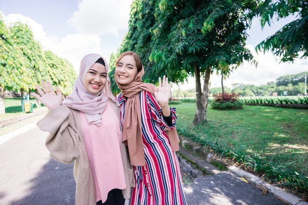 Mulheres muçulmanas em hijabs ao ar livre no dia ensolarado com amigo feliz — Fotografia de Stock