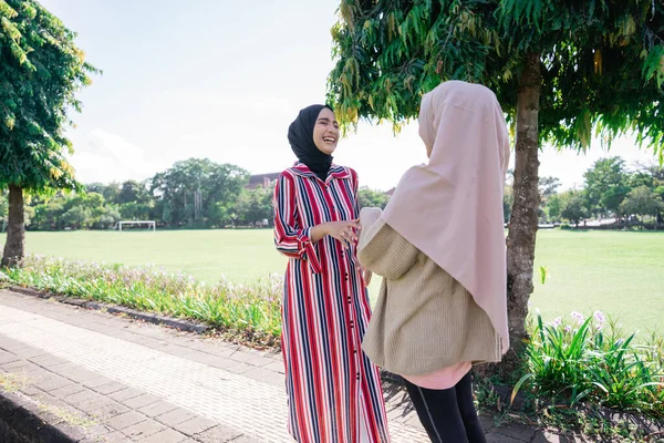 Mujeres musulmanas en hijabs al aire libre en un día soleado con un amigo feliz — Foto de Stock