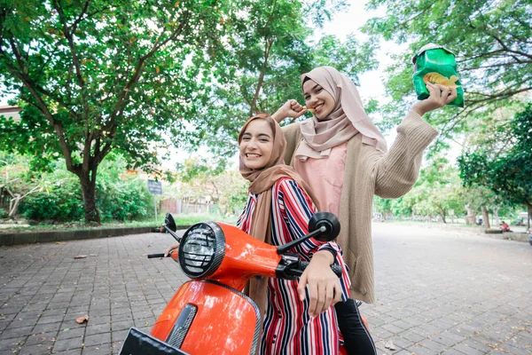 Glad muslimsk vän åker motorcykel scooter tillsammans — Stockfoto