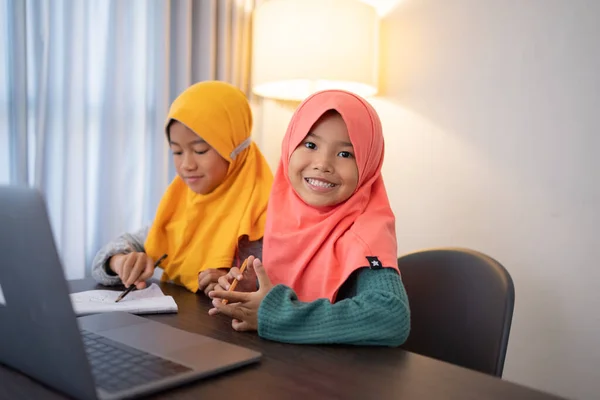 带着笔记本电脑笑着的年轻的穆斯林孩子 — 图库照片