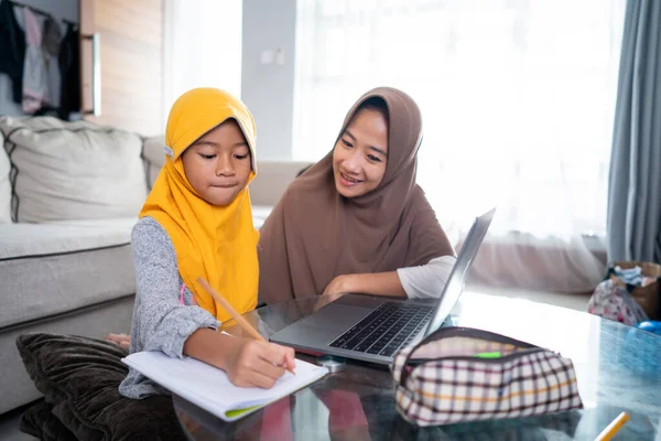 Mutter hilft ihrer Tochter mit Laptop von zu Hause aus online zu lernen — Stockfoto