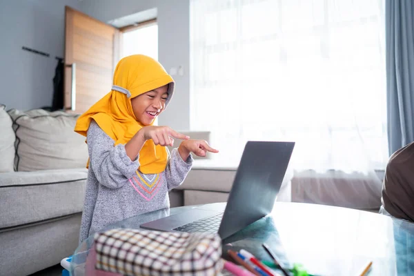 Animado jovem garoto muçulmano enquanto estudava online a partir de casa — Fotografia de Stock