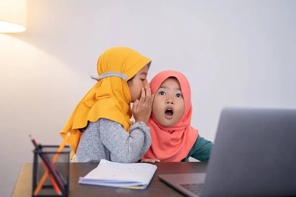 Hermana pequeña susurrando algo a su hermano y sorprendida —  Fotos de Stock