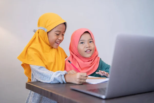 Zwei glückliche junge Kinder, die zu Hause zusammen lernen — Stockfoto