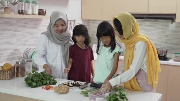 Muslimische Mutter und ihre Kinder kochen gemeinsam zu Hause und bereiten sich auf das Iftar-Abendessen vor — Stockvideo