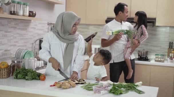 Familia musulmana con dos niños cocinando juntos en casa preparándose para la cena de iftar — Vídeo de stock