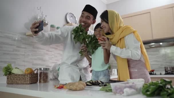 Familia musulmana haciendo un video, selfie o una llamada telefónica juntos durante la preparación de la cena iftar — Vídeos de Stock