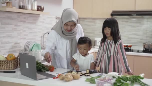 Dejlig asiatisk kvinde med datter og søn madlavning middag under ramadanen – Stock-video