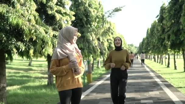 Zwei verschleierte Mädchen treiben beim gemeinsamen Joggen Outdoor-Sport — Stockvideo