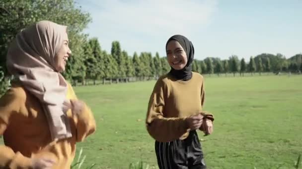 Δύο κορίτσια με πέπλο κάνουν υπαίθρια σπορ ενώ τζόκινγκ μαζί — Αρχείο Βίντεο