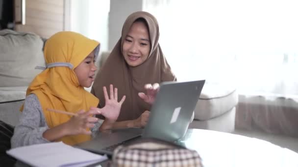 어머니는 집에서 공부하는 노트북을 사용하여 인터넷을 배우도록 딸을 도와 준다 — 비디오