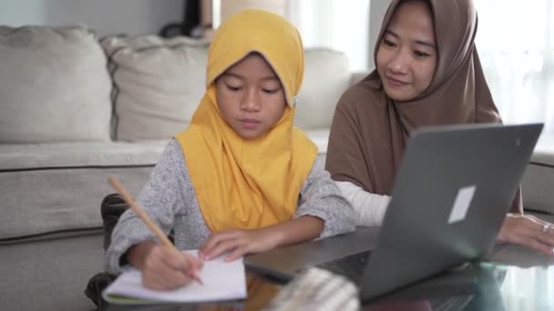 Moeder helpen haar dochter om online te leren met behulp van laptop studeren van thuis — Stockvideo