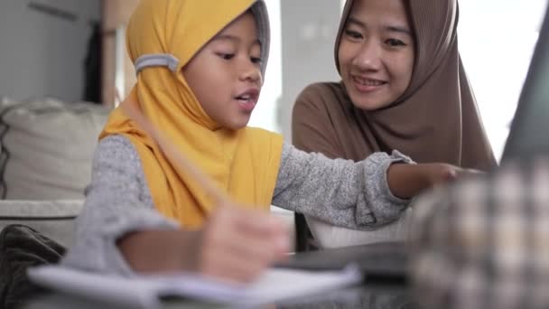 Moeder helpen haar dochter om online te leren met behulp van laptop studeren van thuis — Stockvideo