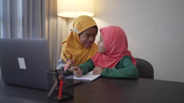 Anak-anak muslim memakai jilbab tersenyum sambil menggunakan komputer laptop — Stok Video