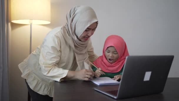 Moslim moeder helpen haar dochter om te studeren tijdens thuisonderwijs — Stockvideo
