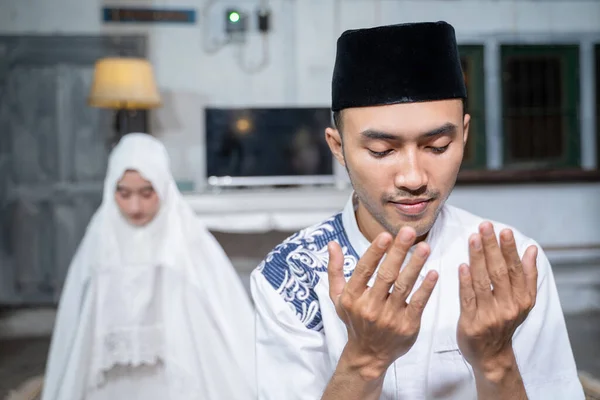 muslim husband and wife praying jamaah together at home