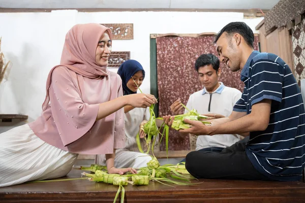 Familia musulmana y amigo haciendo ketupat para eid fitr mubarak — Foto de Stock