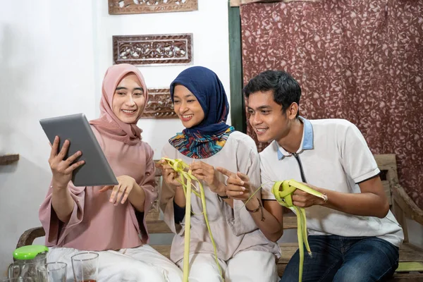 Família muçulmana e amigo fazendo ketupat para eid fitr mubarak — Fotografia de Stock