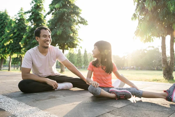 Padre e hija pequeña hacen ejercicios al aire libre. Estilo de vida saludable de la familia con el niño — Foto de Stock