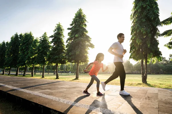 Asiatico padre e piccola figlia fare esercizi in all'aperto. Stile di vita sano della famiglia con bambino — Foto Stock