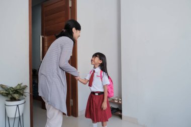 Okula dönelim. İlkokul üniformalı Asyalı öğrenci okula hazırlanıyor.