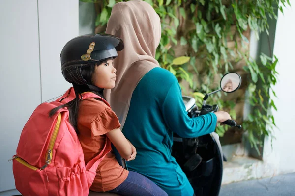 Мусульманська мати везе свою дочку до школи на мотоциклі вранці — стокове фото