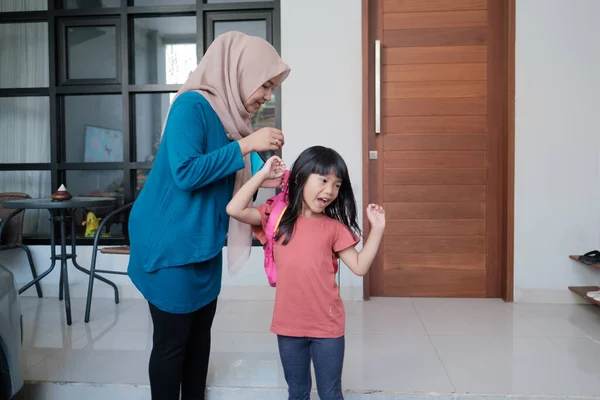 Madre musulmana ayuda a preparar la mochila para su hija en la mañana — Foto de Stock