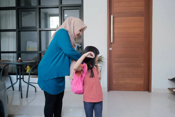 Madre musulmana ayuda a preparar la mochila para su hija en la mañana — Foto de Stock