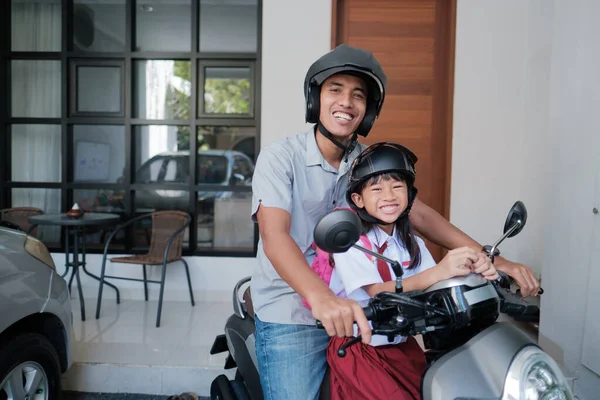 Père emmenant sa fille à l'école en moto le matin — Photo