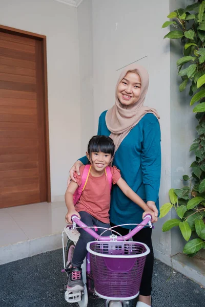 Musulmana y su hija preparándose para ir a la escuela en bicicleta — Foto de Stock