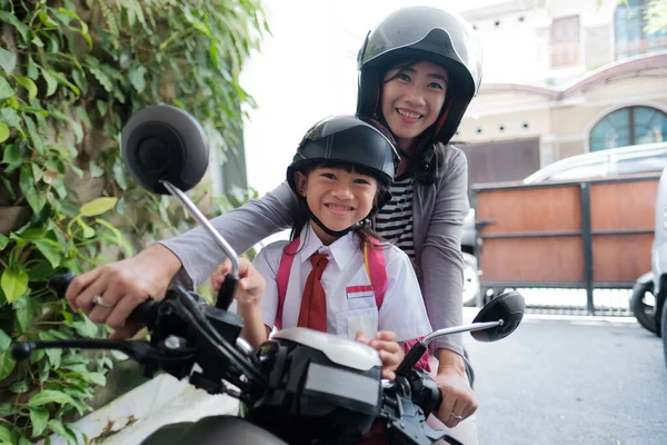 Ibu membawa putrinya ke sekolah dengan sepeda motor di pagi hari — Stok Foto