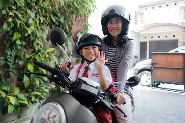 Mãe levando sua filha para a escola de moto pela manhã — Fotografia de Stock