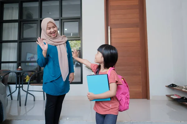 Ibu muslim mengucapkan selamat tinggal sebelum pergi ke sekolah untuk putrinya — Stok Foto