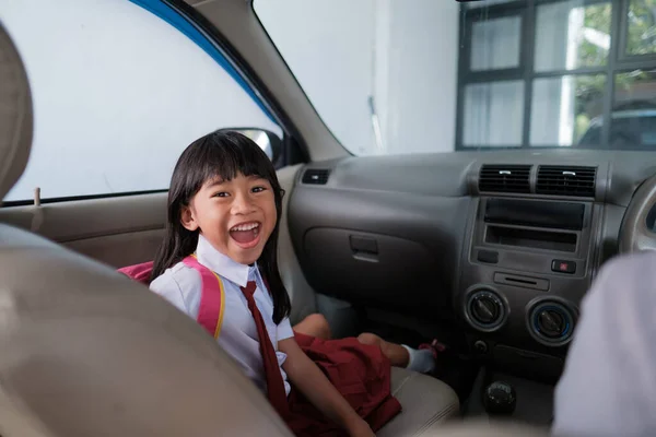 車で学校に行くと幸せなアジアの小学生が — ストック写真