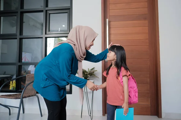 Estudiante de primaria sacudir y besar a sus madres musulmanas mano — Foto de Stock