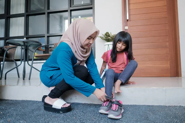 Anne, sabah kızının ayakkabı giymesine yardım et. — Stok fotoğraf