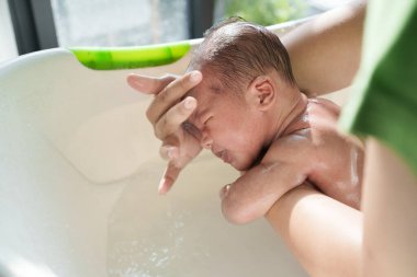 Yeni doğmuş bebek sabah banyo yapıyor.