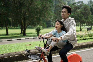 Abi, kız kardeşini bisikletle parka götür.