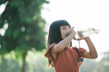 Kız egzersiz yaptıktan sonra şişeden su içer.