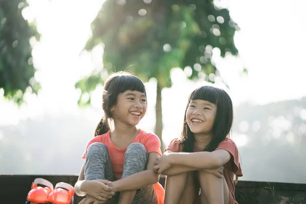 Två asiatiska barn tar en paus i parken på morgonen — Stockfoto