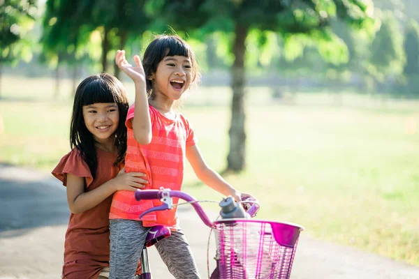 Dos niños disfrutan de paseo en bicicleta en el parque juntos —  Fotos de Stock