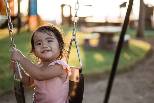 Asiatique fille jouer sur une balançoire et avoir du plaisir dans parc — Photo