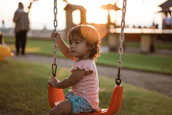 Asiatique fille jouer sur une balançoire et avoir du plaisir dans parc — Photo